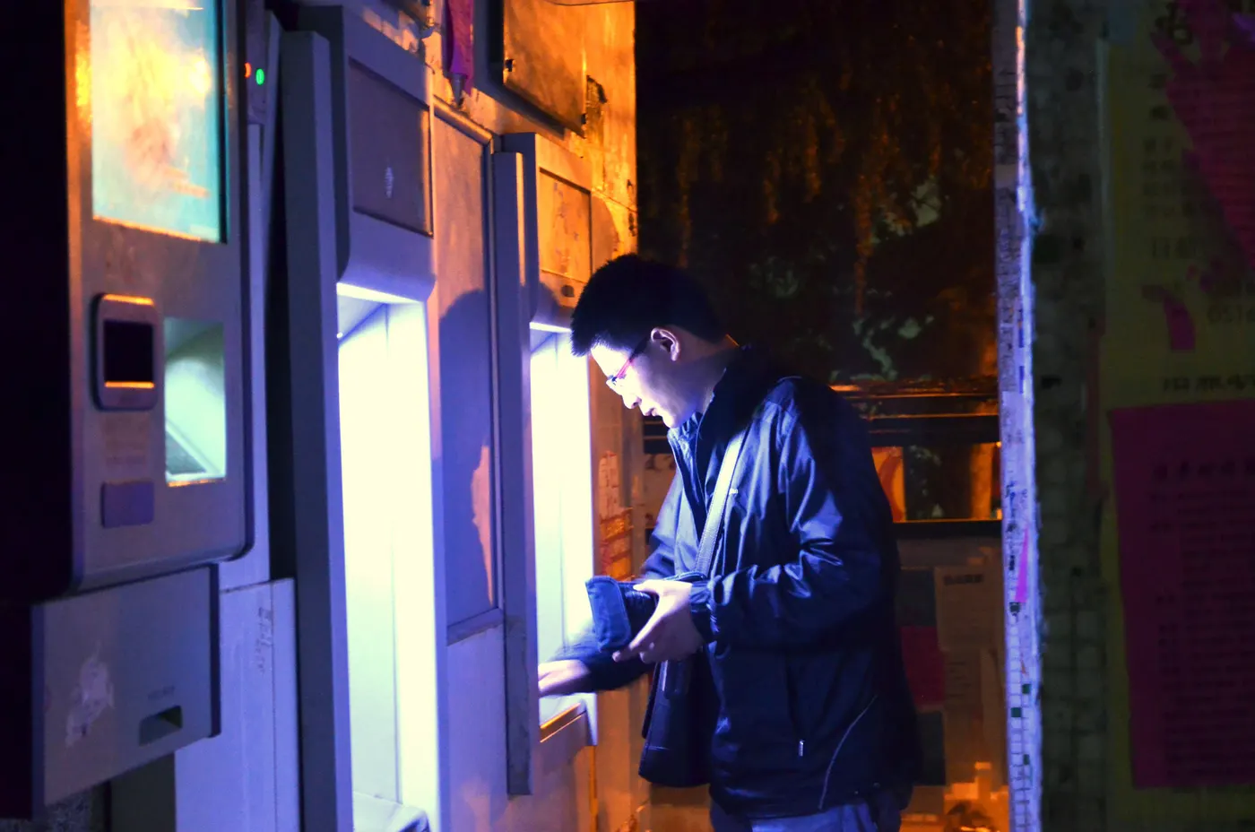 A person withdrawing cash and checking their balance at a bank ATM